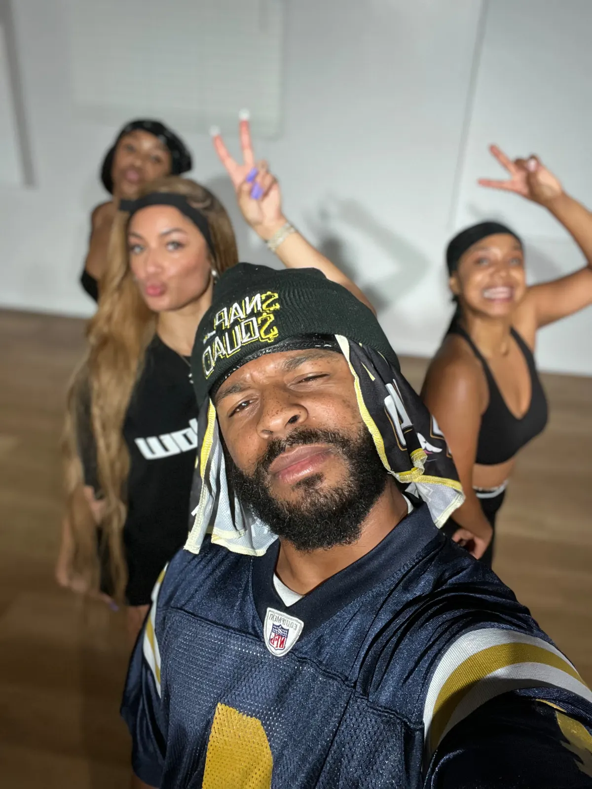 Taiwan Williams in a $NAP$QUAD beanie leading dancers in the studio